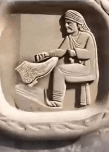 a statue of a man sitting on a chair holding a book