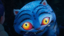 a blue cat with orange eyes and teeth looks at the camera