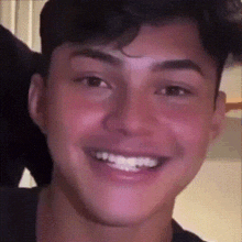 a young man with braces on his teeth smiles for the camera .