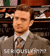 a man in a suit and tie is making a funny face and saying `` seriously ? ''