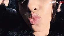 a close up of a woman 's lips with the words manon_live behind her