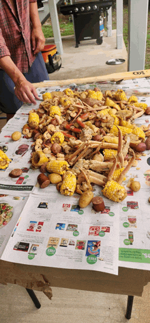 a large pile of food is on a table with a newspaper that says ' coles ' on it