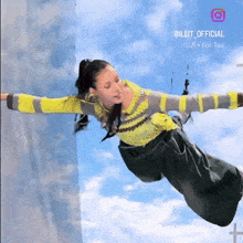 a girl is flying through the air with the words illit official written on the bottom