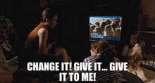 a man is sitting in front of a television with the words `` change it ! give it ! give it to me ! ''