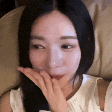 a close up of a woman 's face with her hand on her face