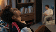 a man laying on a couch looking up at his reflection in the mirror