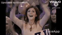 a woman is holding a sign that says face app in front of a crowd