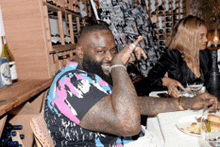 a man and a woman are sitting at a table in a wine cellar .