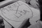 a black and white photo of a person writing the name muriel lisa