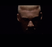 a close up of a man 's face with a beard in the dark
