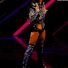 a woman in a black outfit is standing on a stage .