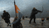 a man with a bow and arrow is standing next to a man with a flag