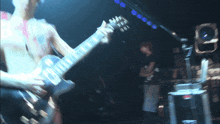 a man playing a guitar in a dark room