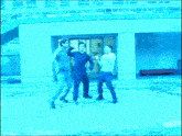 a group of men are standing in front of a building with a blue background