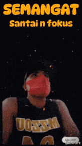 a man wearing a mask and a jersey that says uoswm