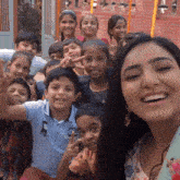 a group of children are posing for a picture with a woman in the foreground