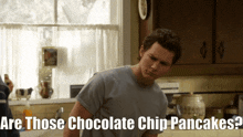 a man in a kitchen with the words " are those chocolate chip pancakes " on the bottom