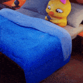 a bed with a blue comforter and a yellow duck on it