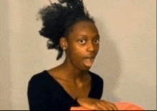 a woman in a black shirt is making a funny face