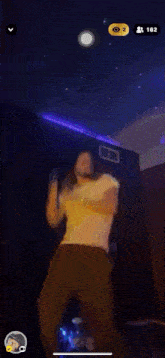 a man in a white shirt is dancing in a dark room with purple lights .