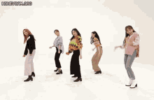 a group of women are dancing in a line on a white background