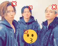 three men are standing next to each other and one has a yellow smiley face on his head