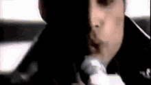 a close up of a person singing into a microphone