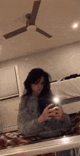 a girl is taking a picture of herself in the mirror