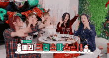 a group of girls are sitting around a table with balloons and a christmas tree .