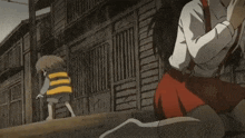a person in a red skirt is sitting on the ground next to a cardboard box .