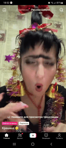 a screenshot of a woman 's face on a phone with the time of 18:52 on it