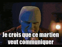 a man with a mask on his face and the words le crois que ce martien veut communiquer