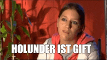 a woman is sitting in front of a red curtain with the words holunder ist gift written on the bottom .