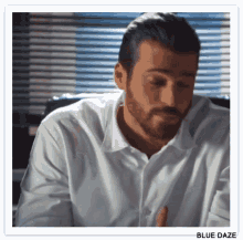 a man with a beard wearing ear buds and a white shirt with the word blue daze below him