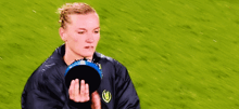 a woman in a blue jacket is holding a blue frisbee in her hands