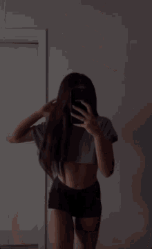 a woman is taking a picture of herself in a mirror with a phone that says ati2230 on the back