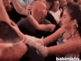 a group of people are standing around a woman in a crowd .