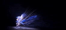 a person is dancing in the dark with a blue light behind them