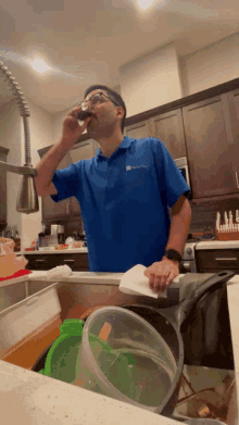 a man wearing a blue shirt that says ' a & a ' on it