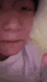 a close up of a person 's face with a white shirt on