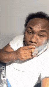 a man in a white shirt is smoking a cigar