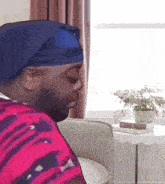 a man wearing a blue headband sits in a chair