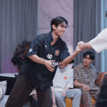 a man wearing a balenciaga shirt shakes hands with someone