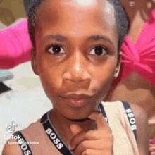 a young boy is wearing a choker around his neck and looking at the camera .