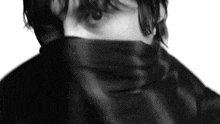 a black and white photo of a person with a scarf around their face