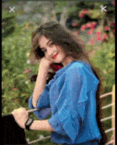 a girl wearing a blue shirt and a watch is looking at her watch