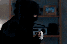 a silhouette of a person standing in front of a shelf with a radio in the background