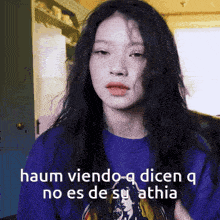 a woman wearing a purple shirt with the words " haum viendo-q dicen q no es de su athia "