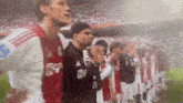 a group of soccer players are standing in a line on the field .