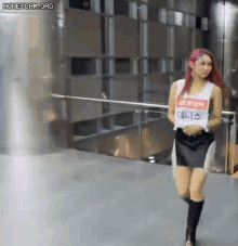 a woman with red hair is walking in front of a building .